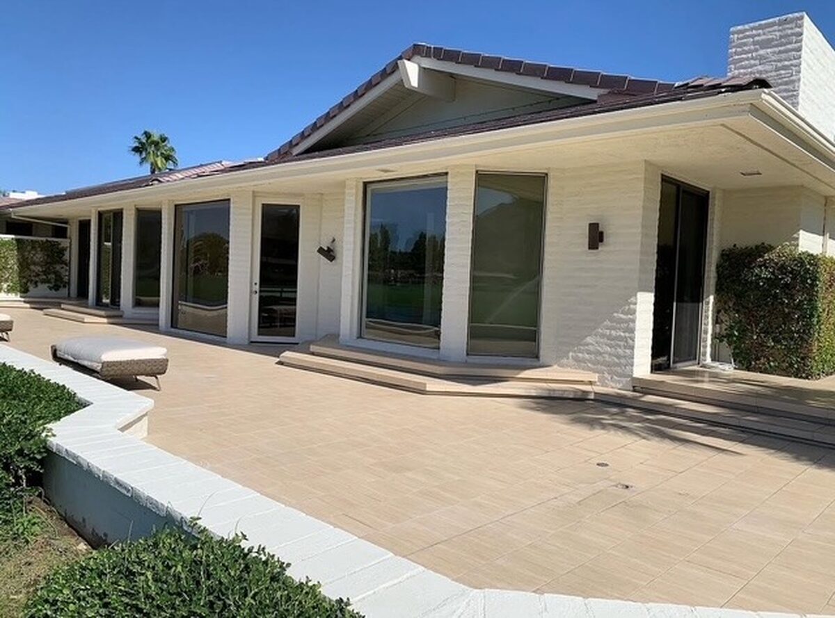 Painted single-story house with wide windows and a patio
